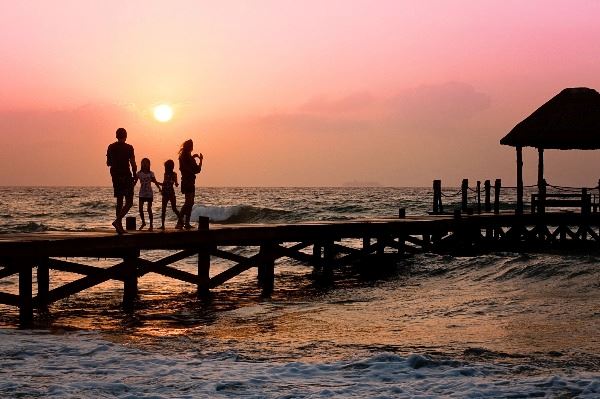 Family of 4 on an ocean pier at sunset