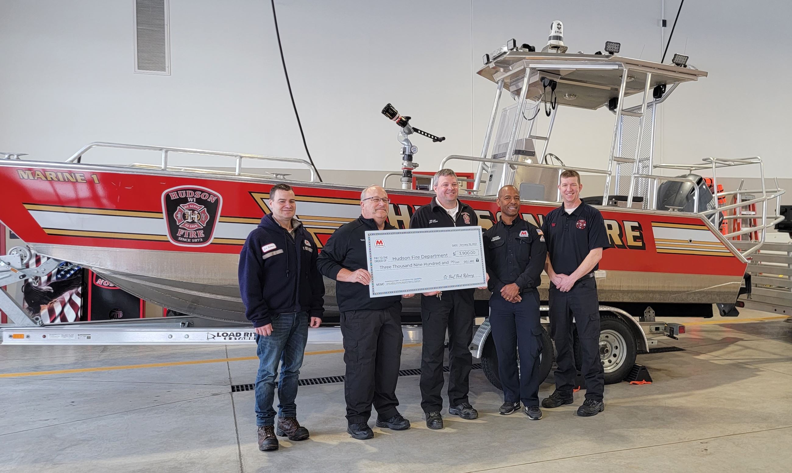 Firefighters holding large check donated from Marathon Stations